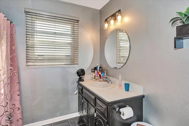 a bathroom with a sink a mirror and a window