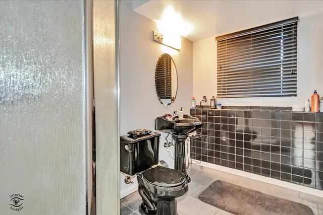 a bathroom with a sink a toilet and a mirror