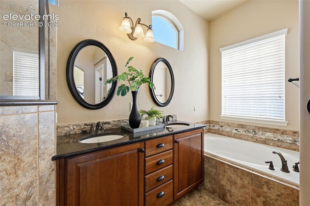 13184 Cake Bread Heights Colorado Springs, CO 80921 - Photo 23 of 47 Master bathroom with double vanity and alcove tub