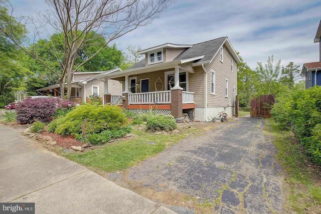 a front view of a house with a garden and trees
