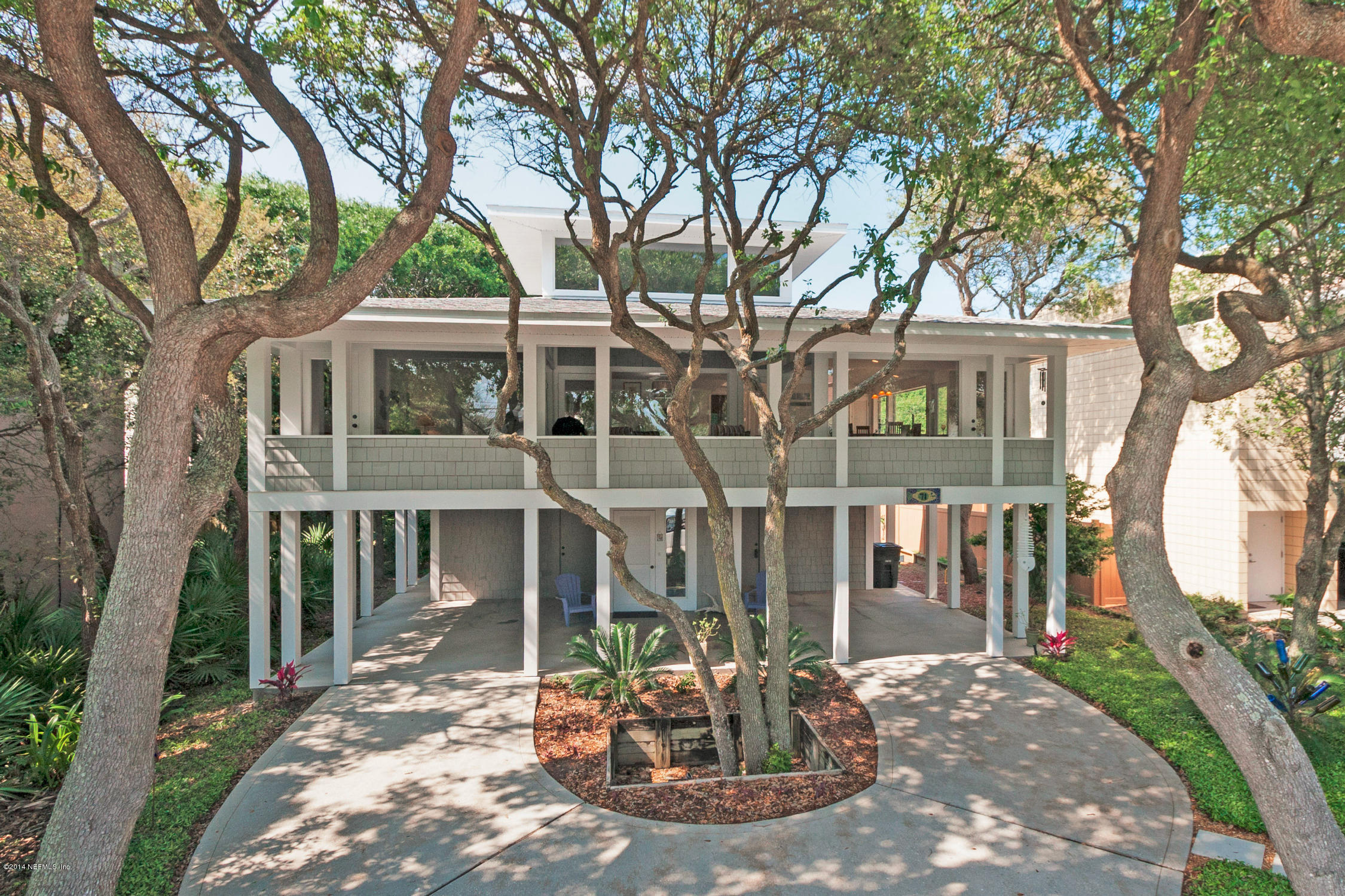 71 19th Street Atlantic Beach, FL 32233 - Photo 3 of 30 a view of a house with brick walls plants and large trees