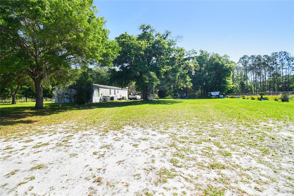 12500 Hamlin Road Spring Hill, FL 34610 - Photo 11 of 82 a view of a swimming pool with an outdoor space and seating area