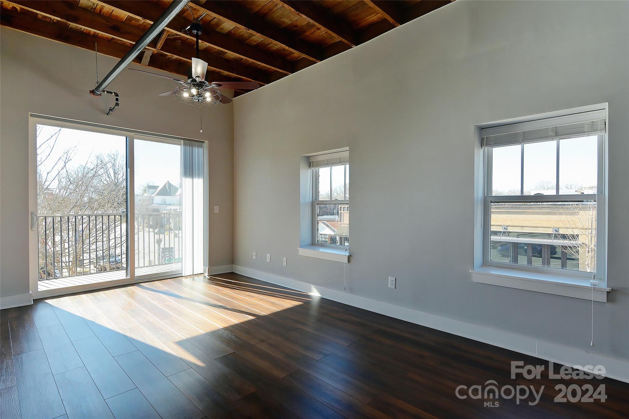 115 South Main Street, Unit 202 Monroe, NC 28112 - Photo 1 of 25 a view of an empty room with wooden floor and a window