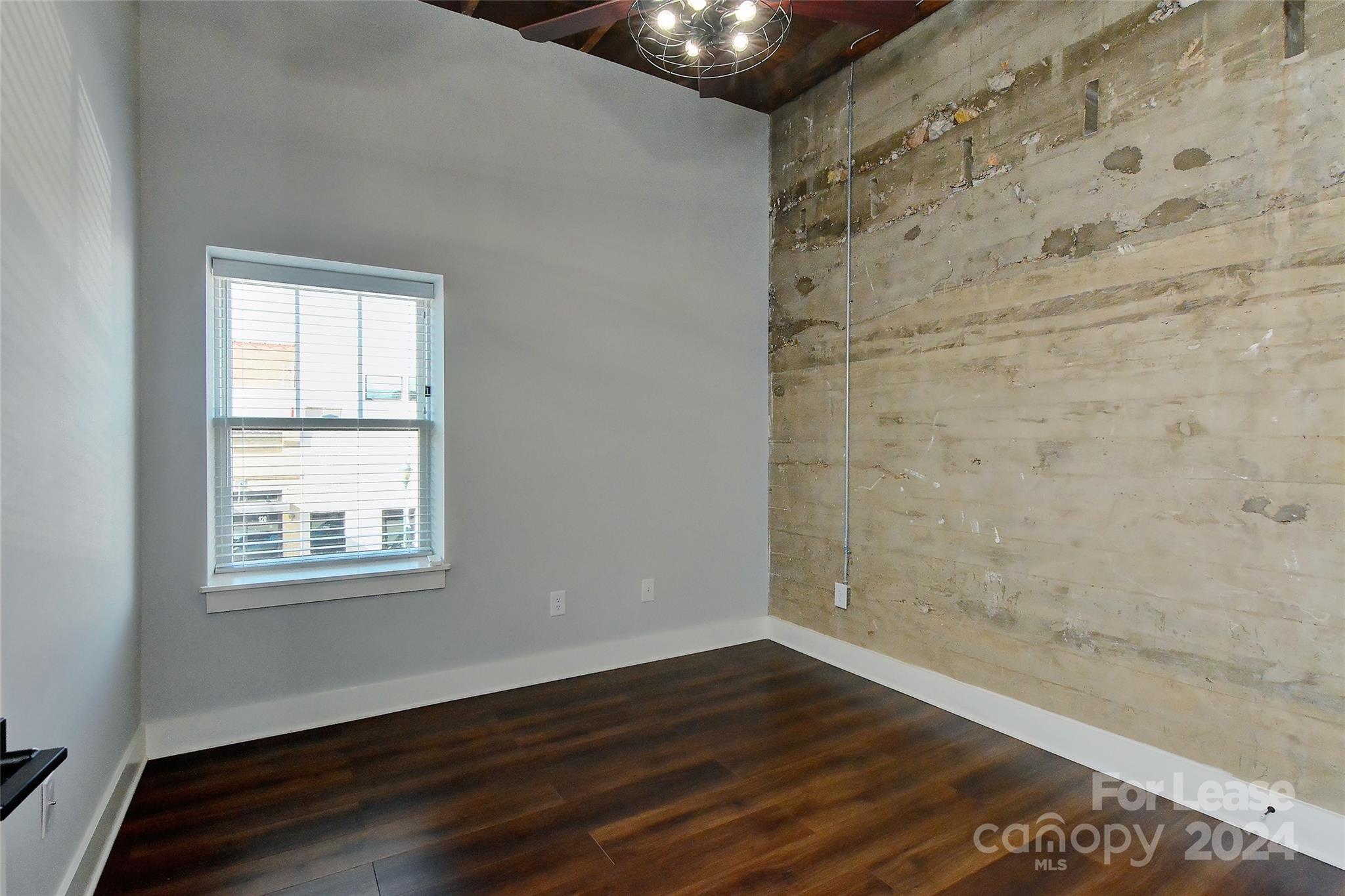 115 South Main Street, Unit 202 Monroe, NC 28112 - Photo 14 of 25 a view of an empty room with wooden floor and a window