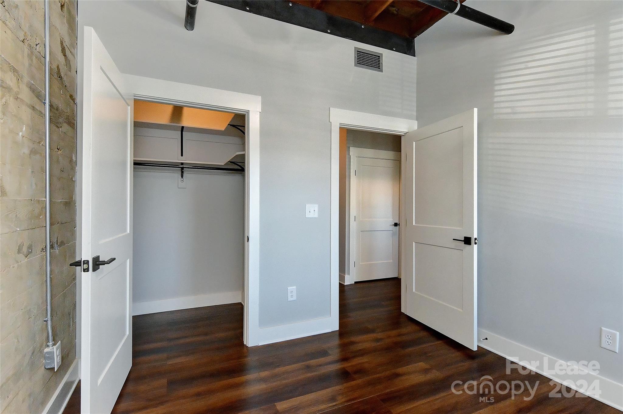 115 South Main Street, Unit 202 Monroe, NC 28112 - Photo 15 of 25 an empty room with wooden floor and a ceiling fan