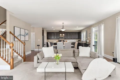 a living room with furniture white walls and a chandelier