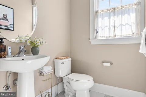a bathroom with a sink a toilet and a mirror