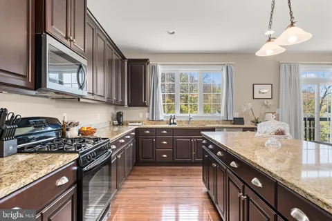 a kitchen with granite countertop a sink stove and cabinets