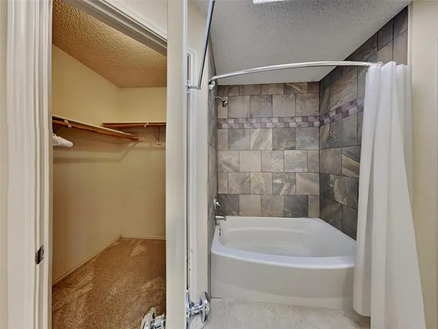 a bathroom with a white bath tub and a shower