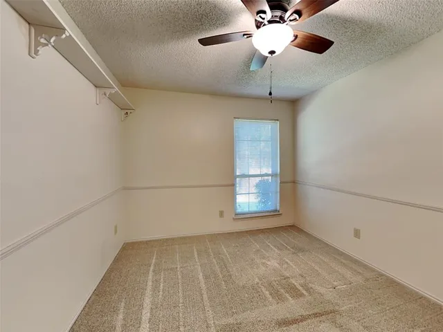 a view of room with a ceiling fan and window