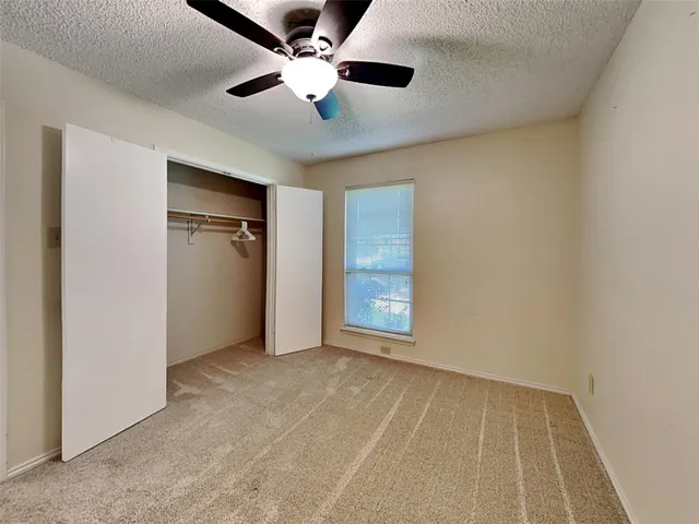 an empty room with chandelier fan