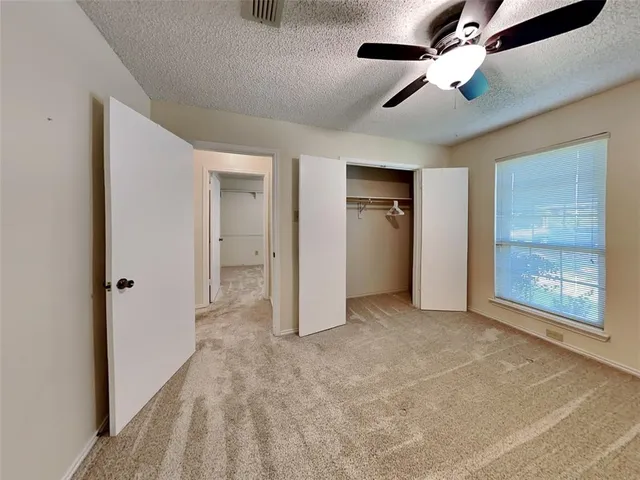 an empty room with fan and windows