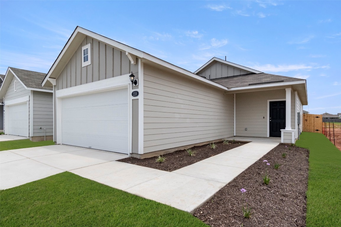 219 Estallo Way Maxwell, TX 78656 - Photo 1 of 1 Ranch-style home featuring board and batten siding, roof with shingles, driveway, and a garage