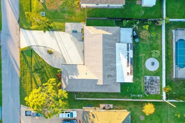 an aerial view of a house with a swimming pool a yard and a fountain
