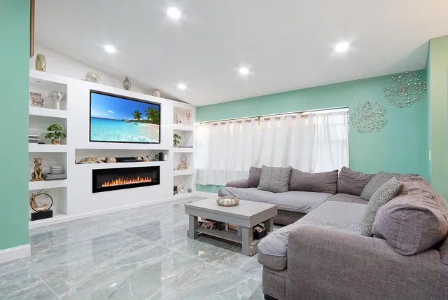 a living room with furniture a fireplace and a flat screen tv