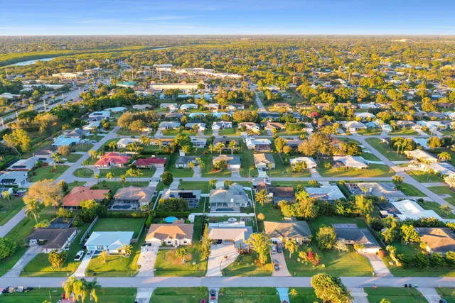 an aerial view of residential houses with outdoor space and ocean view