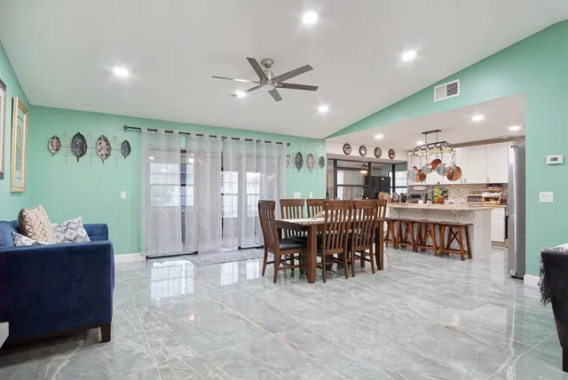a view of a a dining room with furniture and chandelier