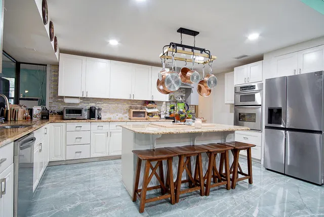 a kitchen with stainless steel appliances granite countertop a sink stove and refrigerator