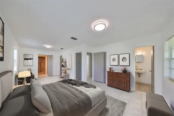 a spacious bedroom with a bed and dresser