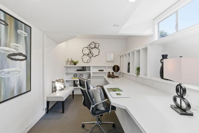 a view of a workspace with furniture and a window