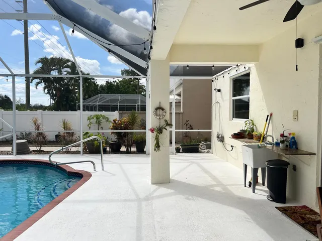 a kitchen with stainless steel appliances a refrigerator a sink a stove a table and chairs