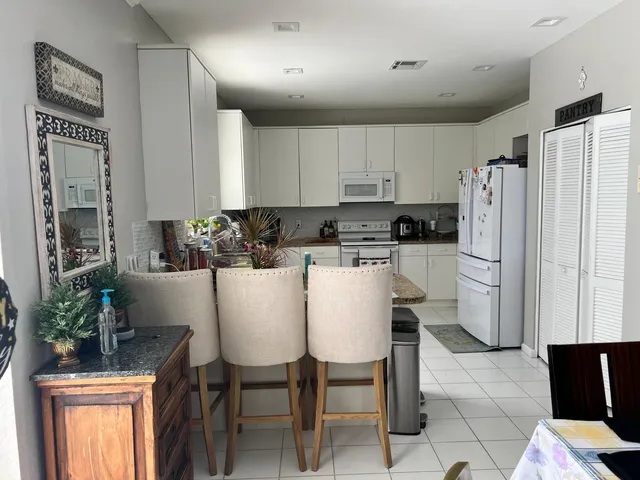 a living room with lots of furniture and kitchen view