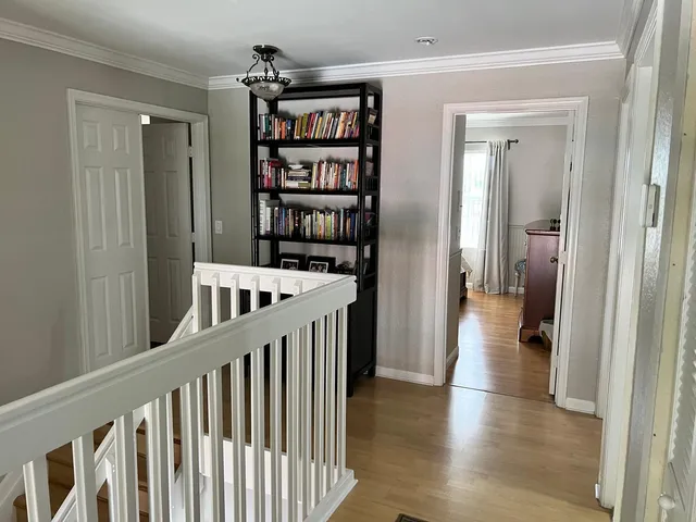a view of a hallway with wooden floor and staircase