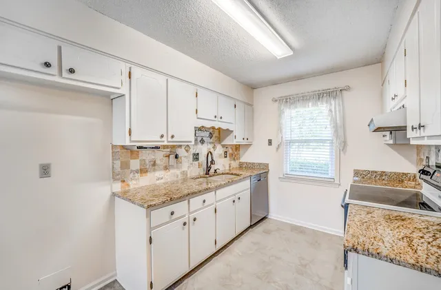 a kitchen with stainless steel appliances granite countertop a sink stove and cabinets