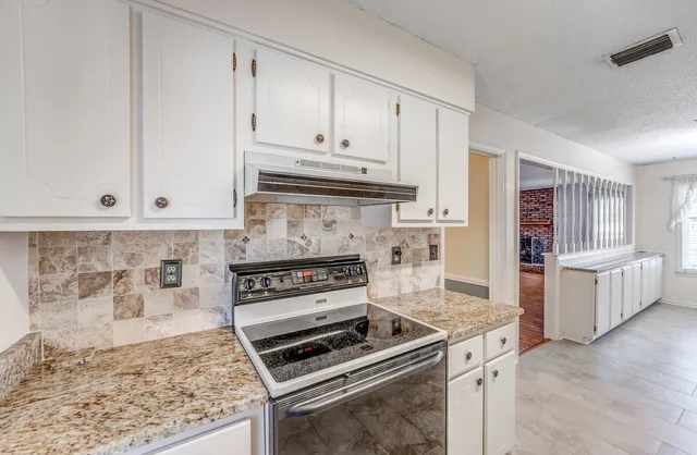 a kitchen with granite countertop a stove and a sink
