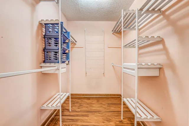 a view of walk in closet with empty racks