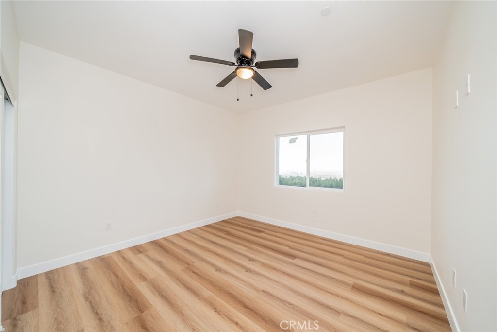 1114 Hollister Road Pinon Hills, CA 92372 - Photo 15 of 61 a view of empty room with wooden floor and fan