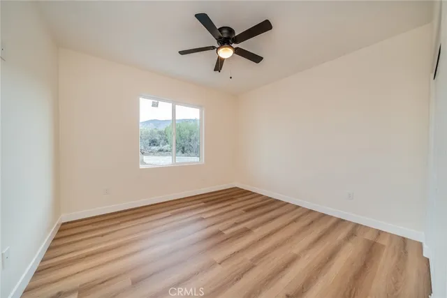 a view of empty room with wooden floor and cabinet