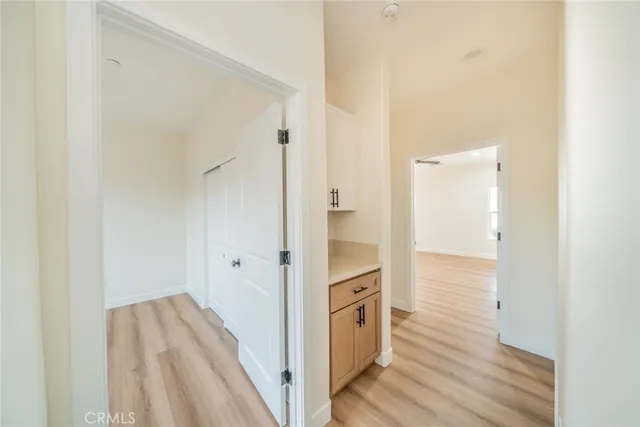 an empty room with wooden floor and ceiling fan