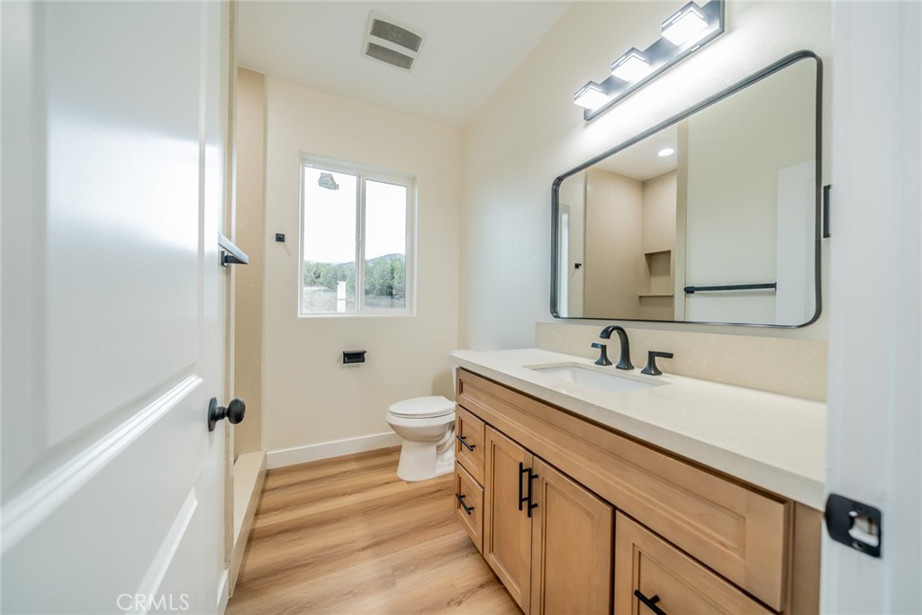 1114 Hollister Road Pinon Hills, CA 92372 - Photo 27 of 61 a bathroom with a sink a toilet a mirror and shower