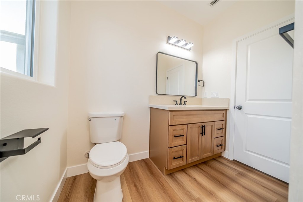 1114 Hollister Road Pinon Hills, CA 92372 - Photo 29 of 61 a bathroom with a toilet a sink a mirror and vanity