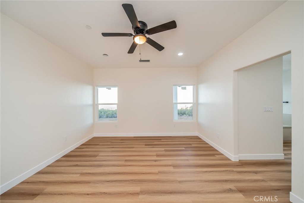 1114 Hollister Road Pinon Hills, CA 92372 - Photo 34 of 61 a view of empty room with wooden floor and fan