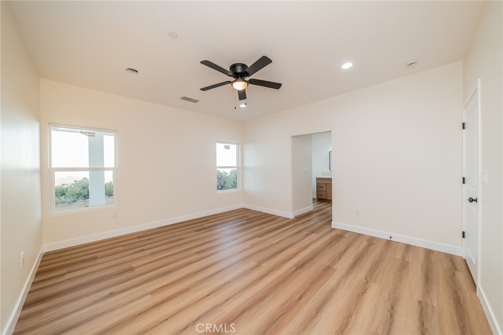 1114 Hollister Road Pinon Hills, CA 92372 - Photo 37 of 61 a view of empty room with wooden floor and fan