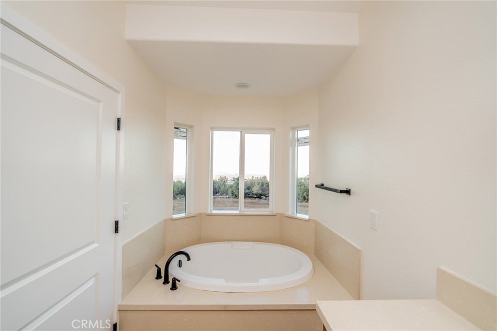 1114 Hollister Road Pinon Hills, CA 92372 - Photo 42 of 61 a bathroom with a bathtub and window