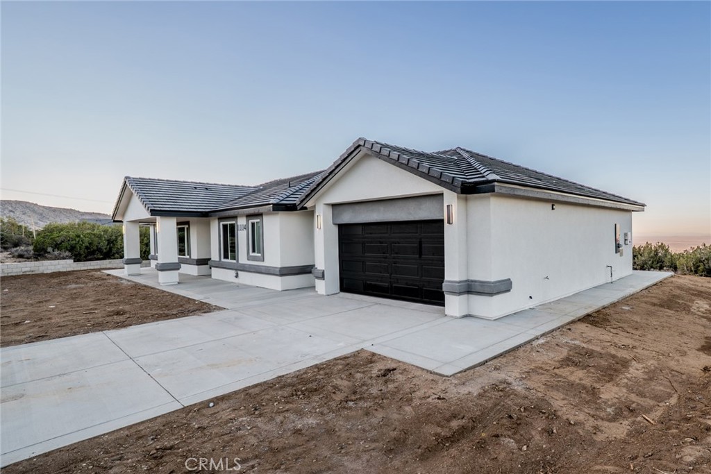 1114 Hollister Road Pinon Hills, CA 92372 - Photo 44 of 61 a front view of a house with yard and garage