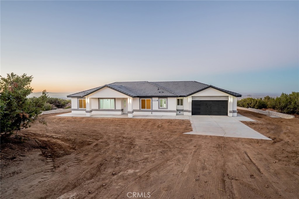 1114 Hollister Road Pinon Hills, CA 92372 - Photo 50 of 61 a front view of a house with a yard and garage