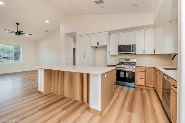 a view of open kitchen with furniture and wooden floor