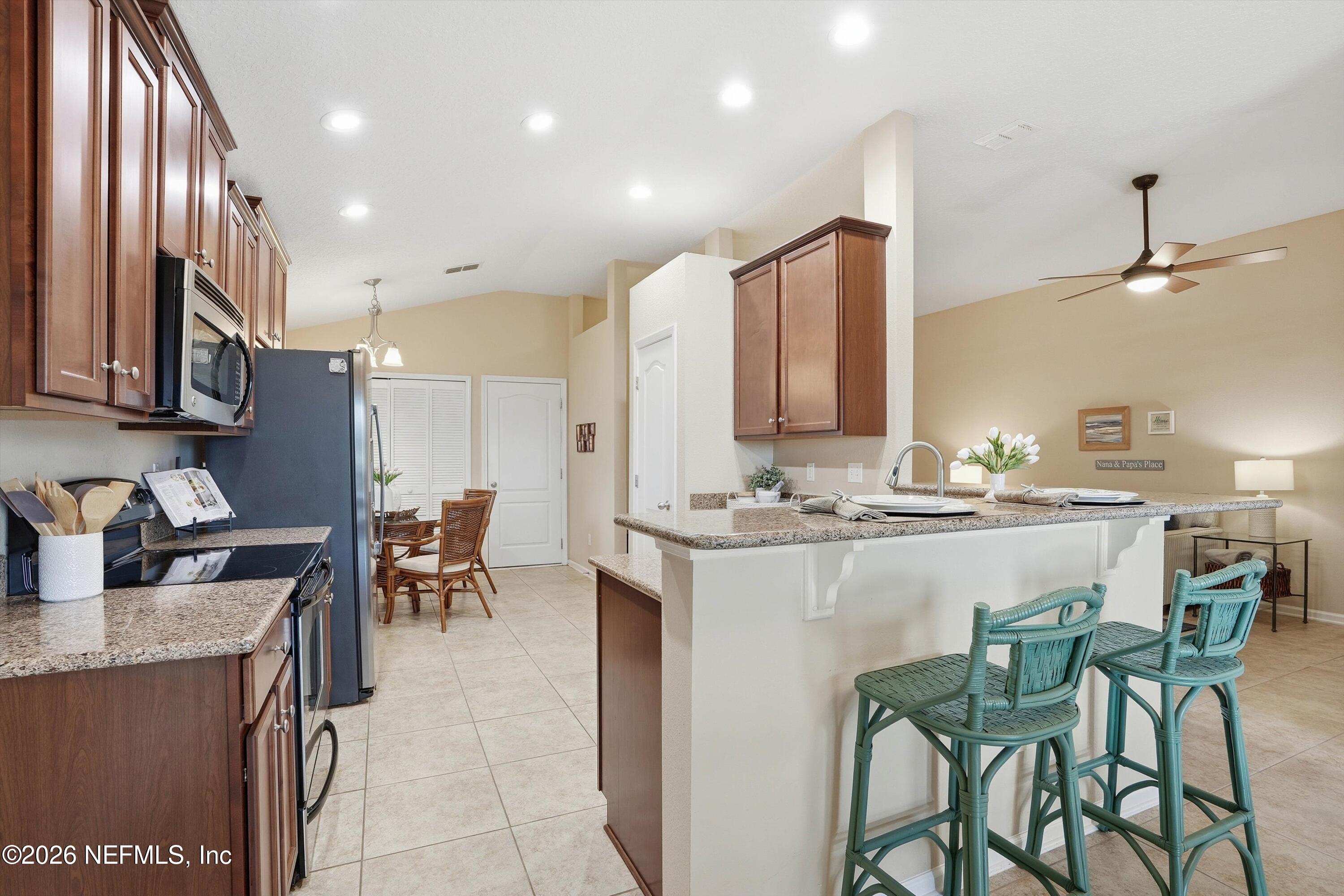 1833 Indigo Street Fernandina Beach, FL 32034 - Photo 11 of 41 a kitchen with a sink a stove a refrigerator and chairs
