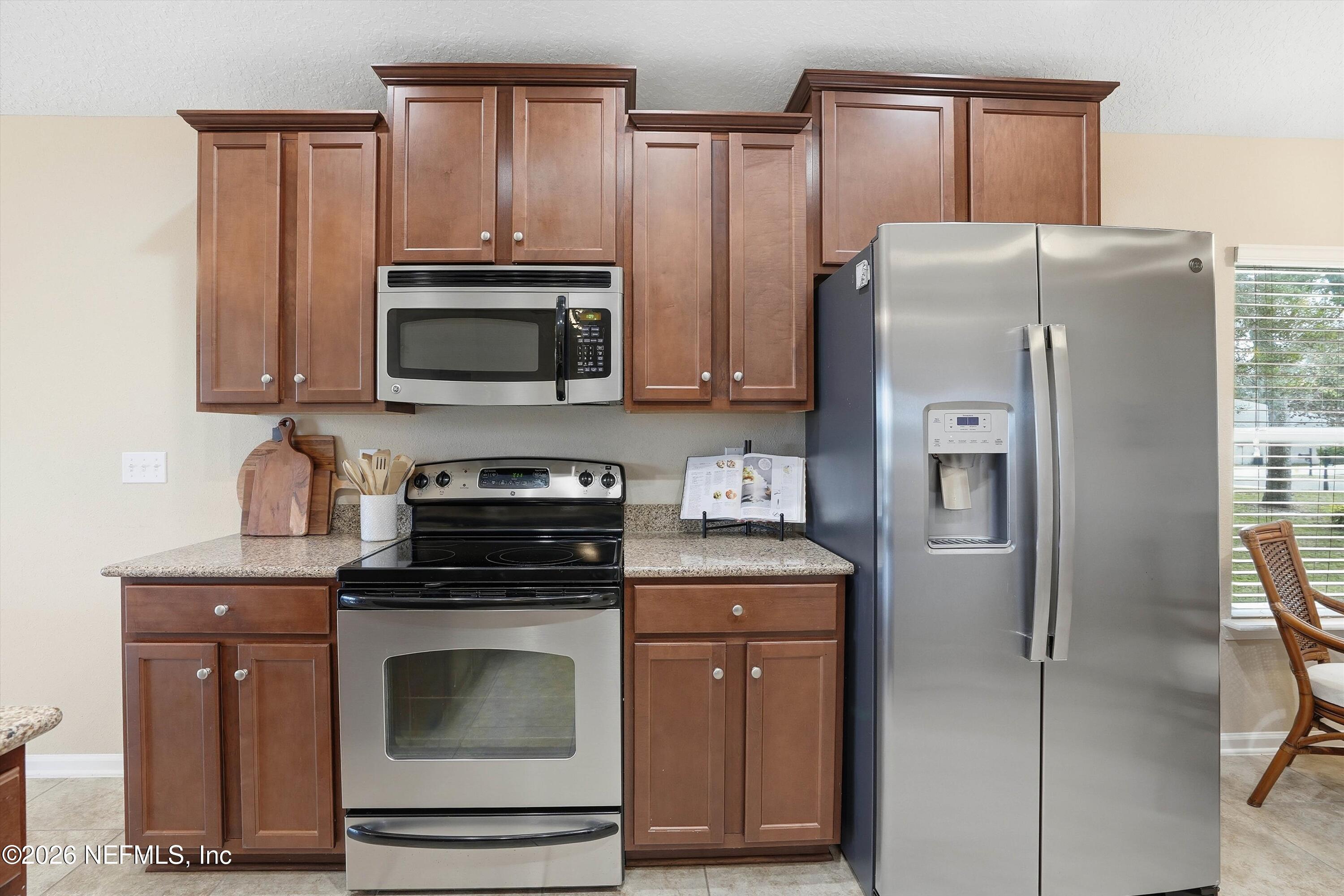 1833 Indigo Street Fernandina Beach, FL 32034 - Photo 12 of 41 a kitchen with granite countertop a refrigerator stove and microwave