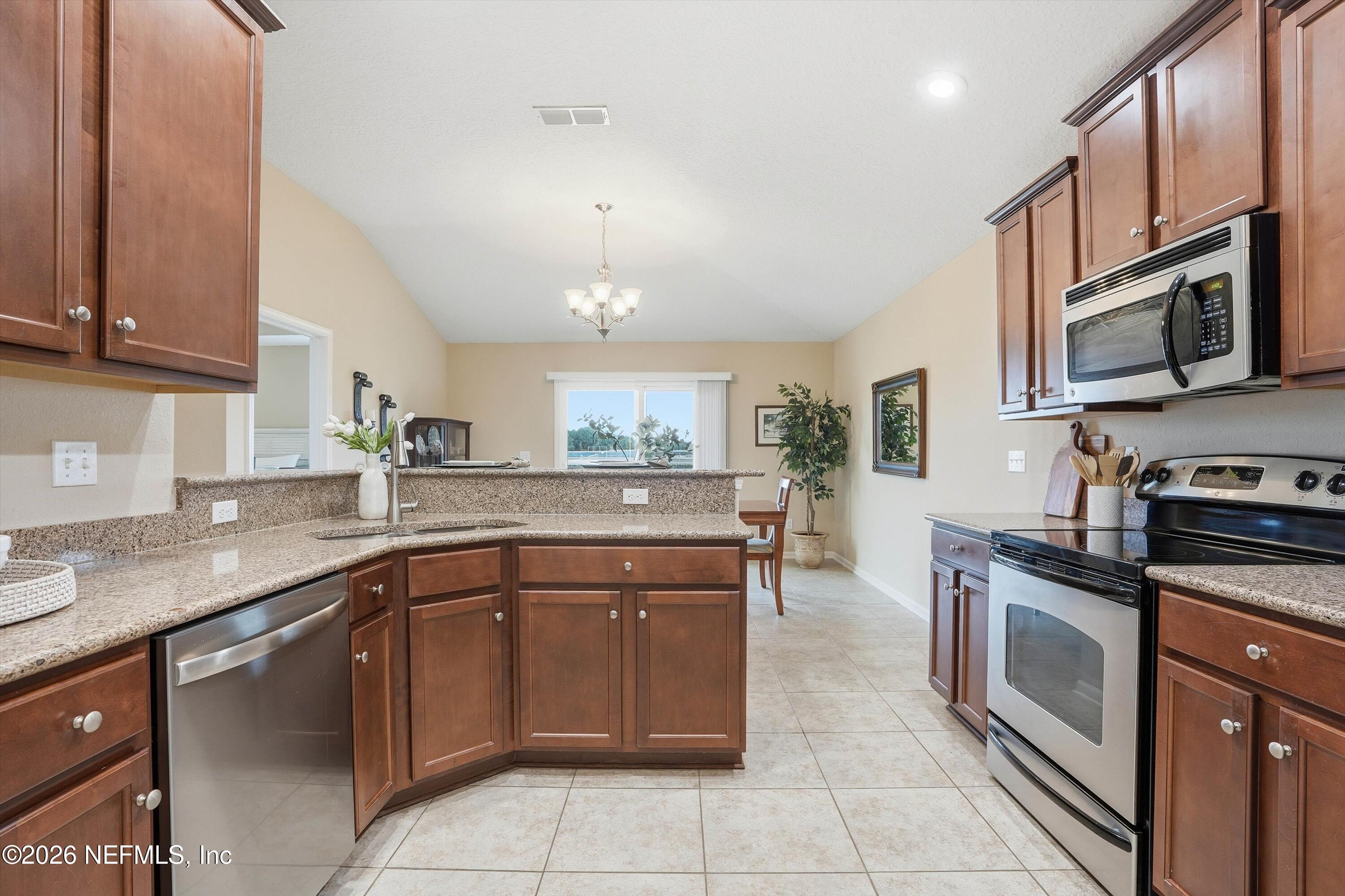 1833 Indigo Street Fernandina Beach, FL 32034 - Photo 13 of 41 a kitchen with stainless steel appliances granite countertop a sink and stove top oven