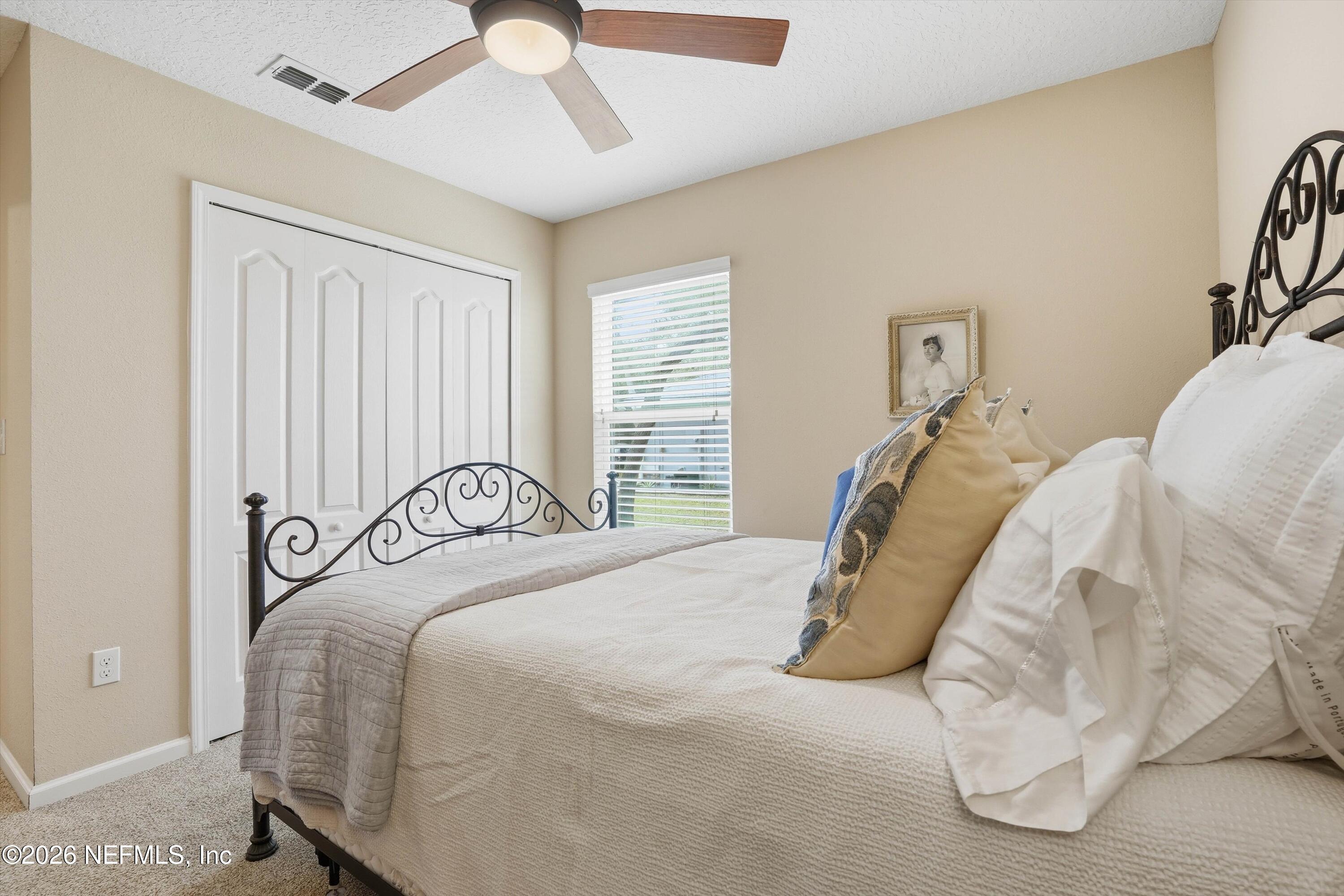 1833 Indigo Street Fernandina Beach, FL 32034 - Photo 22 of 41 a bedroom with a bed and a chandelier