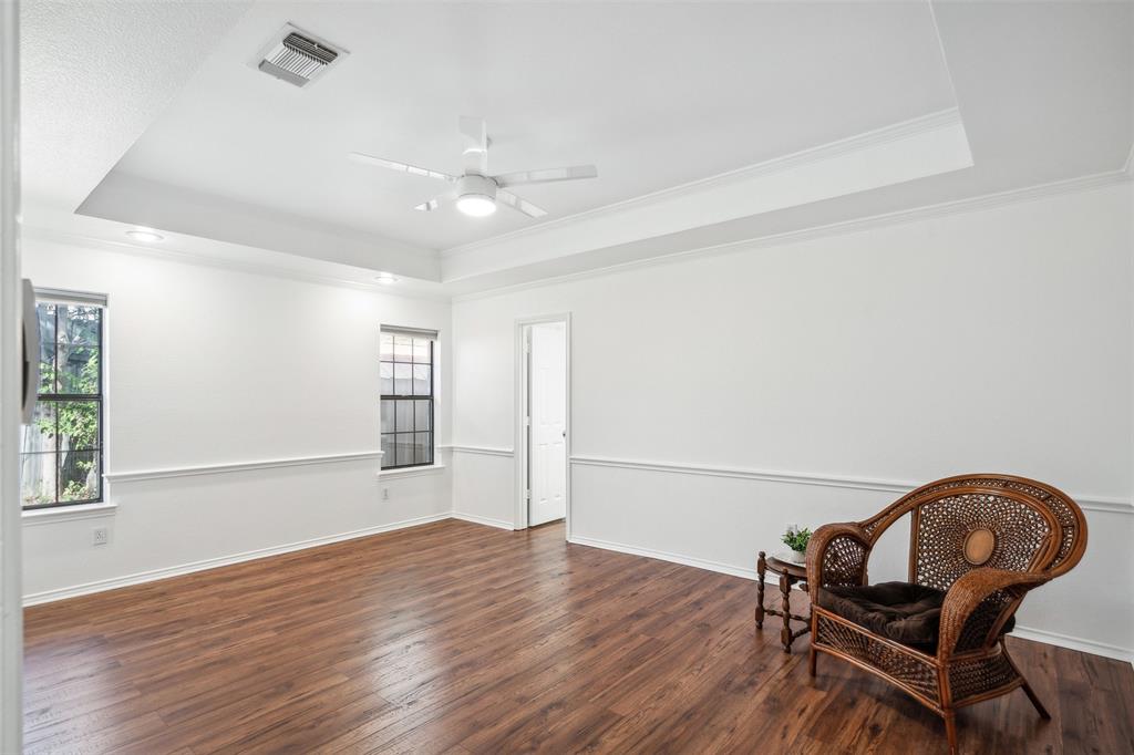 215 Shady Oak Road Keene, TX 76059 - Photo 16 of 26 an empty room with wooden floor windows and ceiling fan