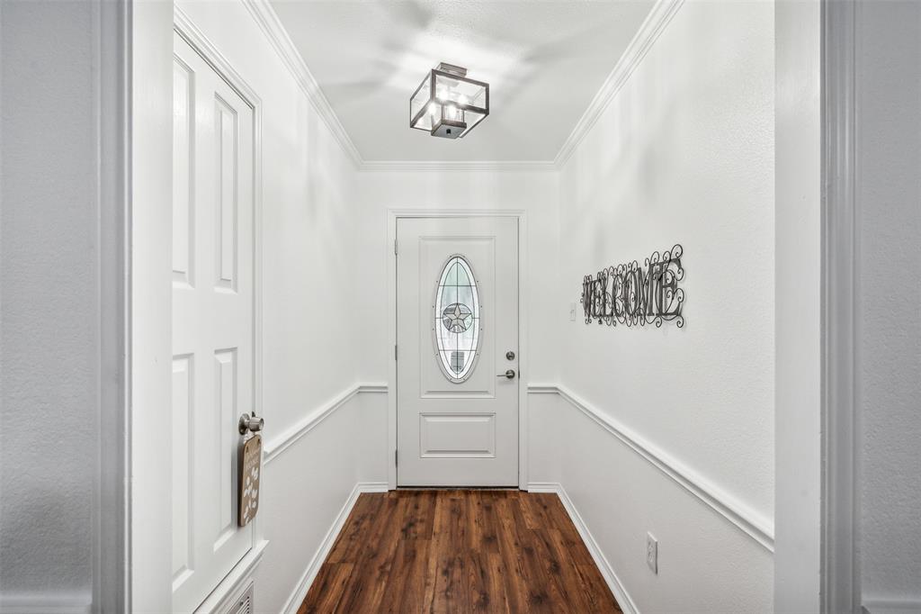 215 Shady Oak Road Keene, TX 76059 - Photo 2 of 26 a hallway with wooden floor a chandelier and entryway