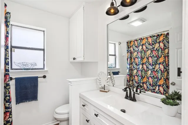 a bathroom with a sink toilet a mirror and shower