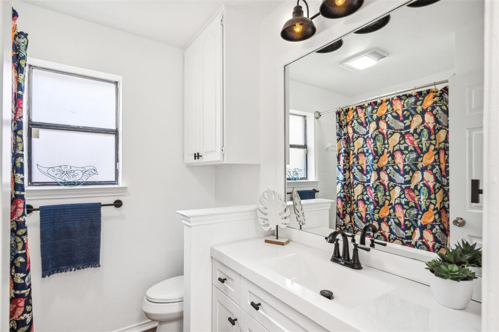 215 Shady Oak Road Keene, TX 76059 - Photo 22 of 26 a bathroom with a sink toilet a mirror and shower