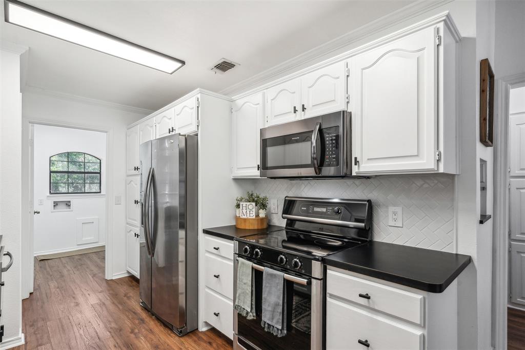 215 Shady Oak Road Keene, TX 76059 - Photo 8 of 26 a kitchen with stainless steel appliances a stove a microwave and a refrigerator